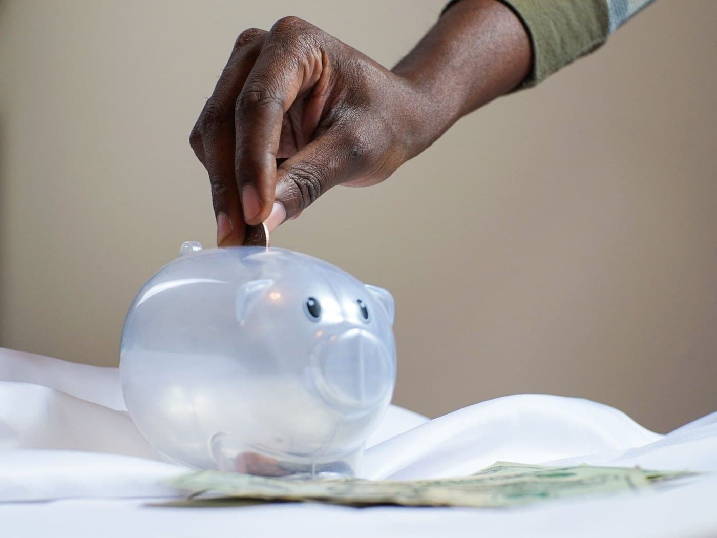 Dropping a coin into a piggy bank — savings from lower electricity bills
